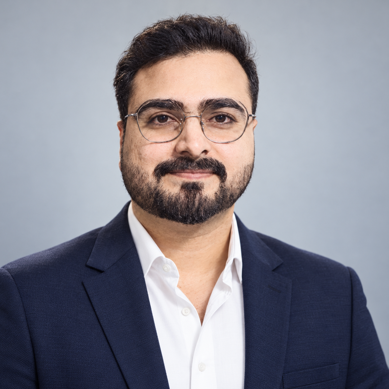 Salman Mehmood wearing glasses and a navy blue blazer